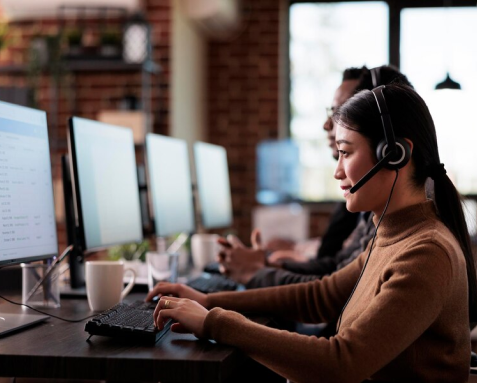 Support team members with headsets working on computers, focusing on managing and monitoring DevOps services for operational efficiency.