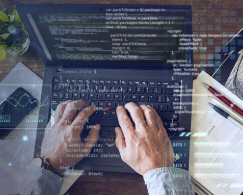 Hands typing on a laptop keyboard with code displayed on the screen, symbolizing software development and outsourcing services. Overlaid text includes code snippets and project-related details.