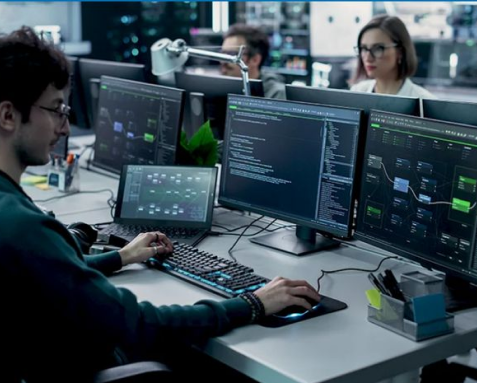 Developers working on multiple screens with complex code, representing Samyak Infotech's scalable enterprise application development services using AngularJS for large organizations.