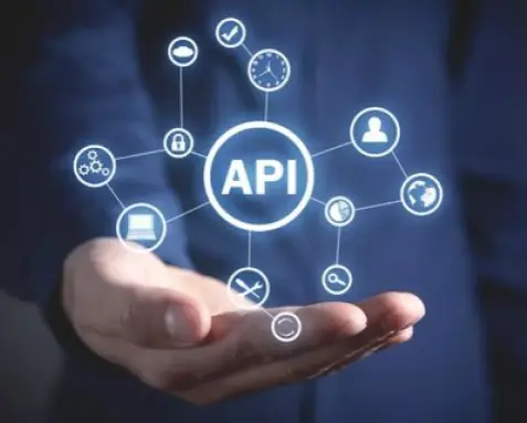 Hand holding holographic icons connected to a central API symbol, illustrating MuleSoft certified developers designing and developing APIs on the MuleSoft Anypoint Platform to meet business requirements and technical specifications.