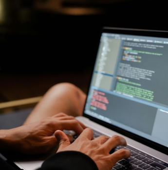 Developer typing code on a laptop, highlighting the importance of keeping apps future-proof with continuous updates and improvements in Flutter development, backed by Google.