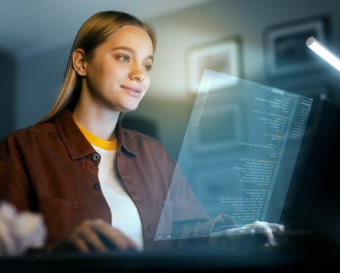 Woman working on a computer with code displayed on a transparent screen, representing Samyak Infotech's offshore software development services that leverage global talent, reduce costs, and ensure high-quality, scalable, and secure software solutions through seamless collaboration with in-house teams.