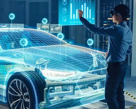 A professional interacts with a digital hologram of a car, symbolizing machine learning development services for the automotive sector, including autonomous driving, predictive maintenance, and advanced driver-assistance systems.