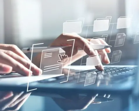 Close-up of hands typing on a laptop with digital document icons floating above, symbolizing the use of Power Automate services for automating document management and case filing in the legal industry, enhancing efficiency and reducing errors.