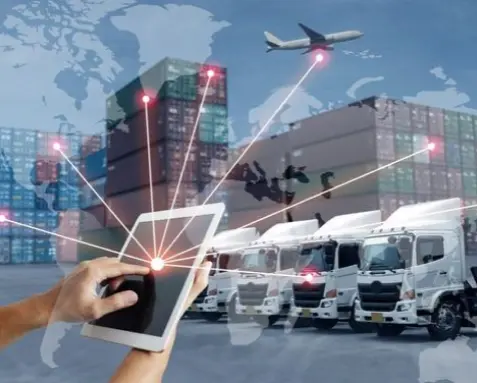 Hands holding a tablet with digital connections overlaying trucks, containers, and an airplane, representing the use of Power Automate services to automate fleet management and logistics in the transportation sector for enhanced efficiency and real-time tracking.